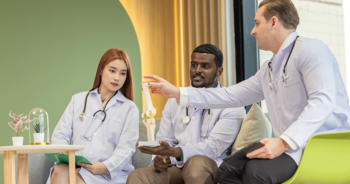 Team of three allied healthcare professionals looking at a bone