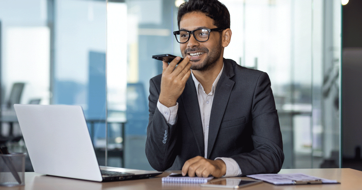 Man on mobile in front of laptop