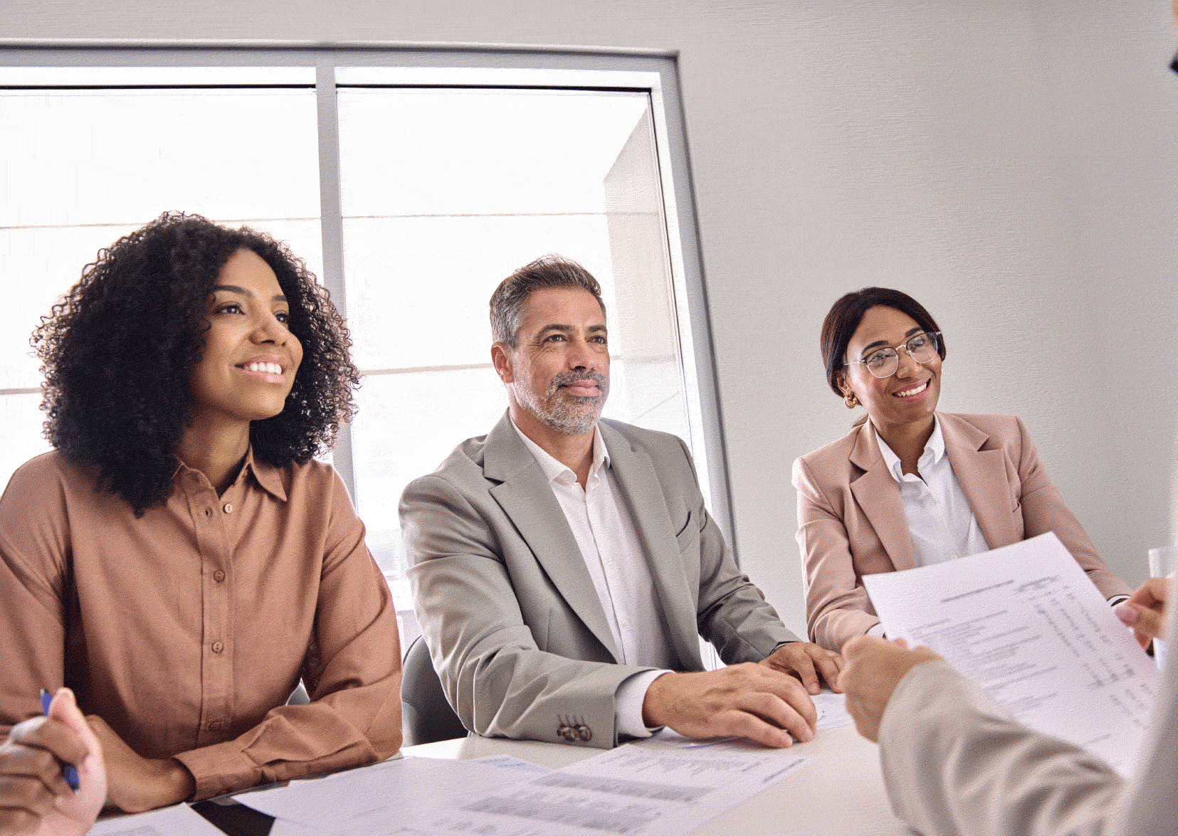 Person being interviewed by two women and a man