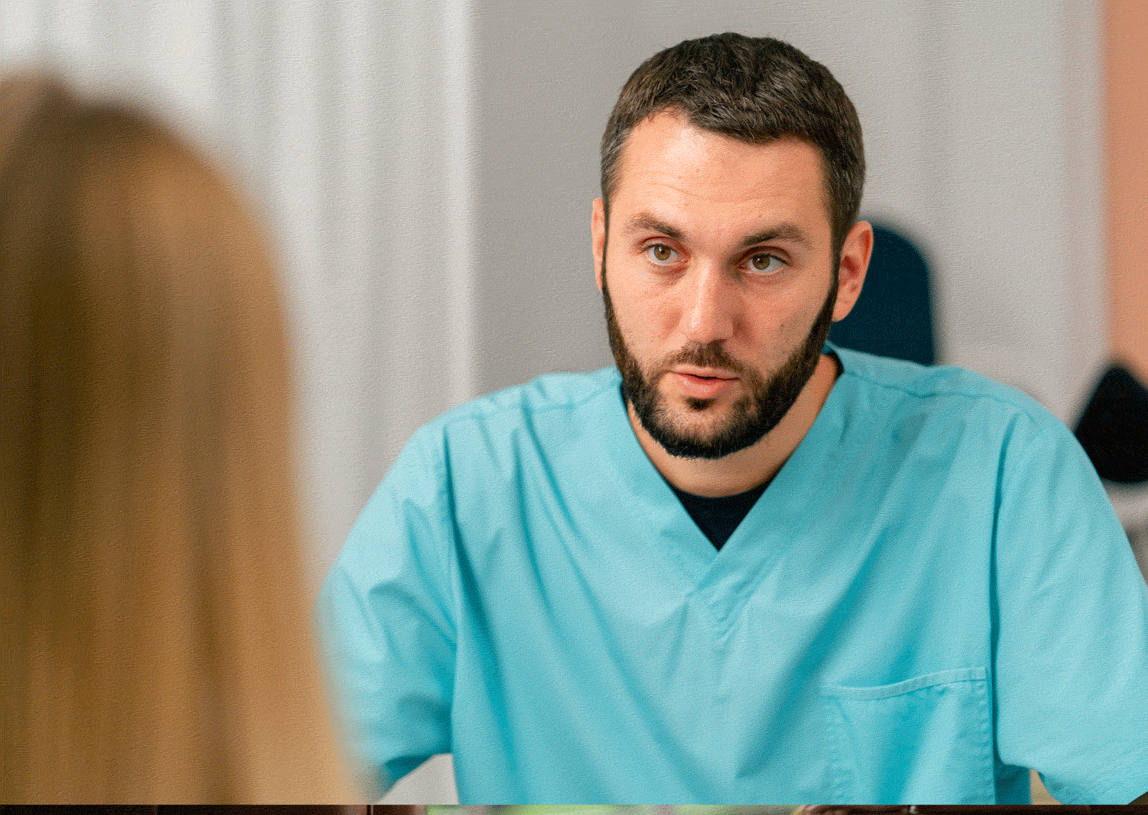 Male nurse in scrubs interviewing candidate