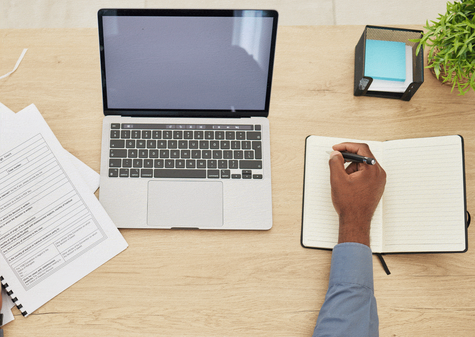 Man in front of laptop with paperwork