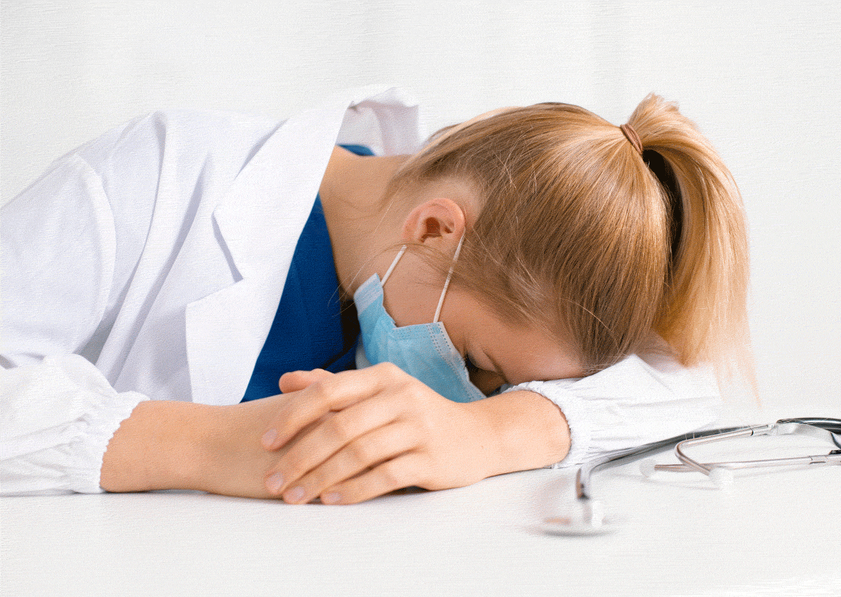 Nurse in scrubs asleep on a table