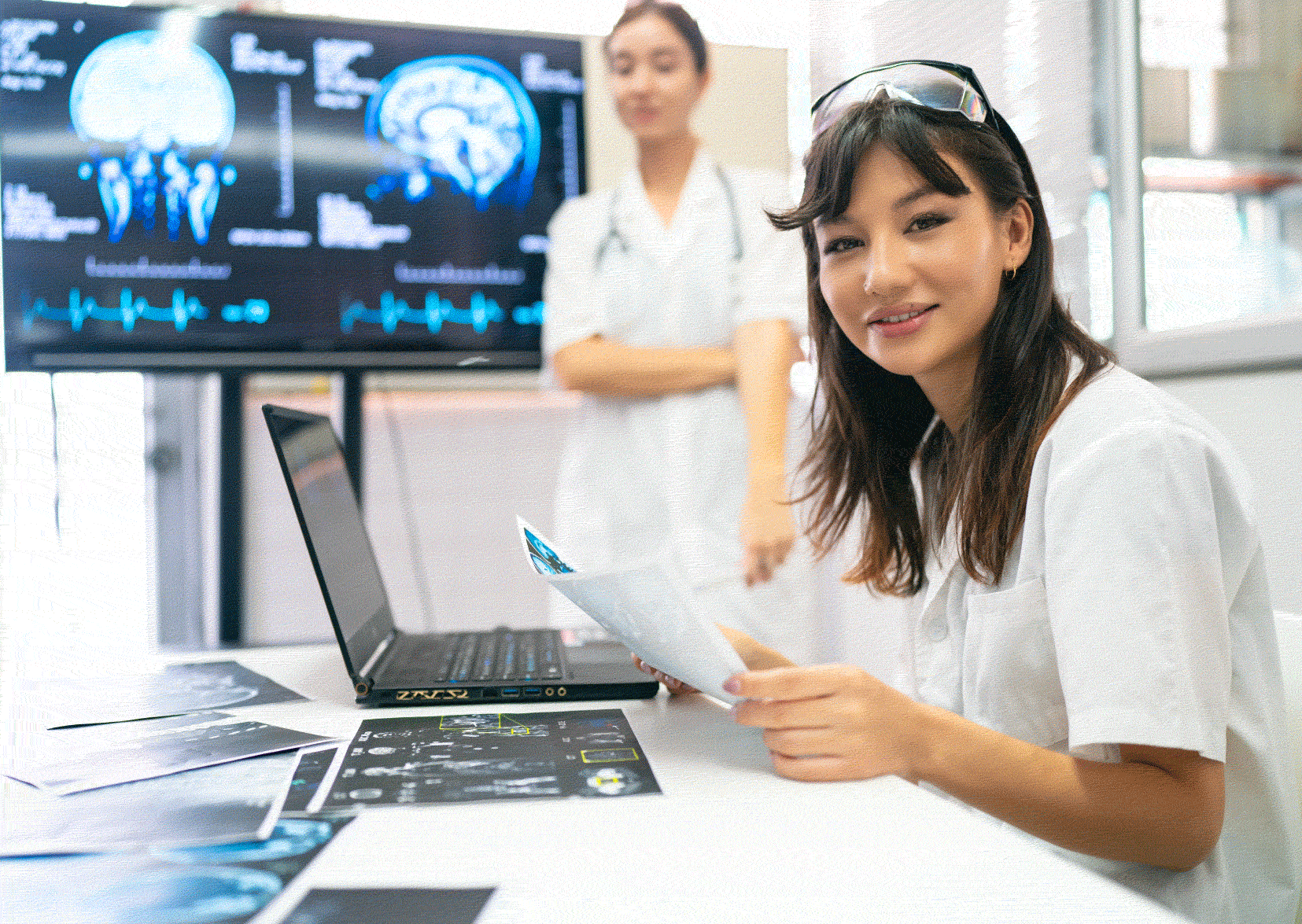 Two nurses in front of an MRI screen