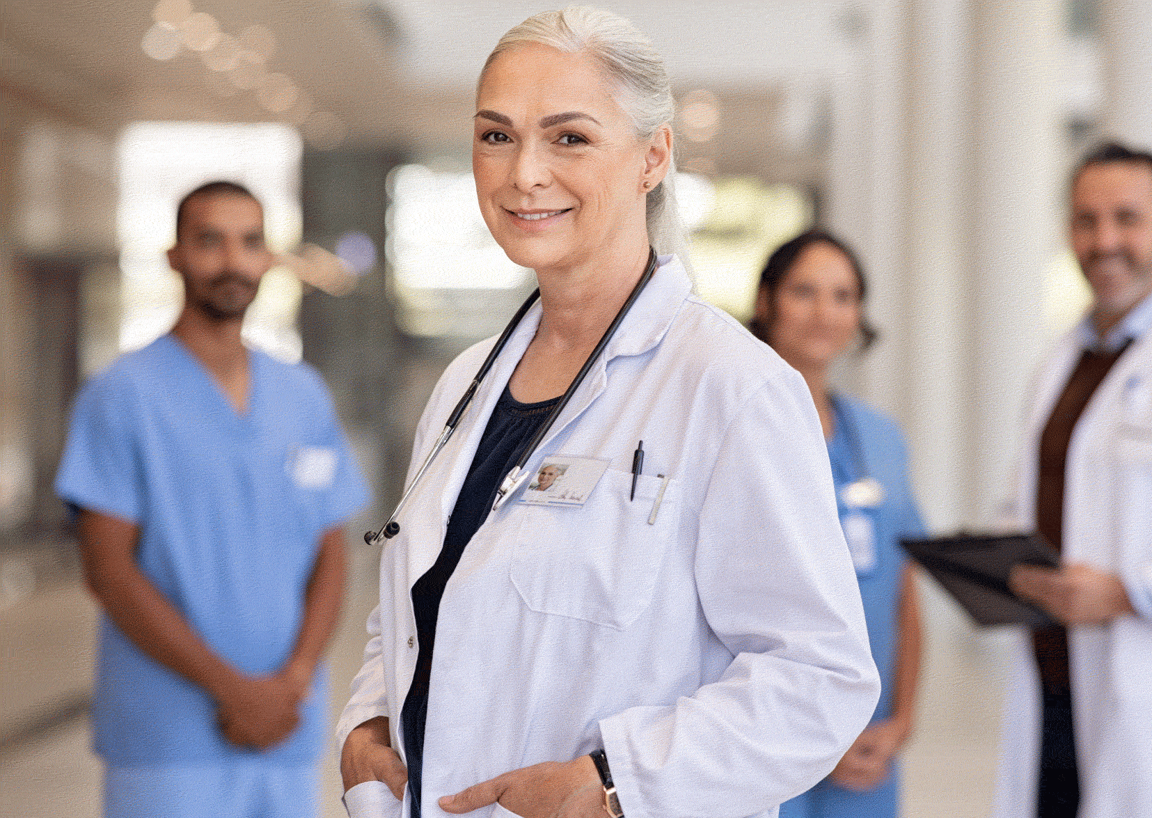 Nurse manager in white in the foreground with three junior nurses behind