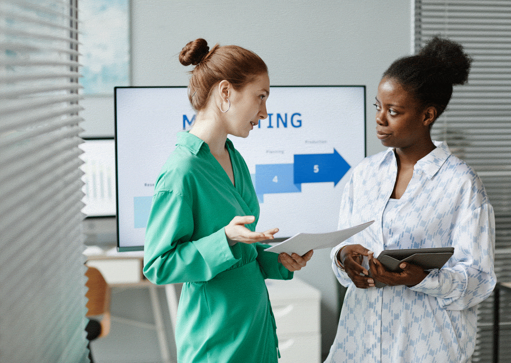 Two nurses in scrubs. Both looking at paperwork